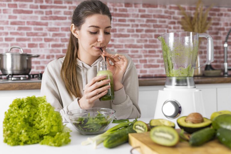 woman drinking green smoothie