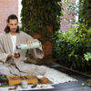 Man pouring ayurvedic tea into a cup from a bottle
