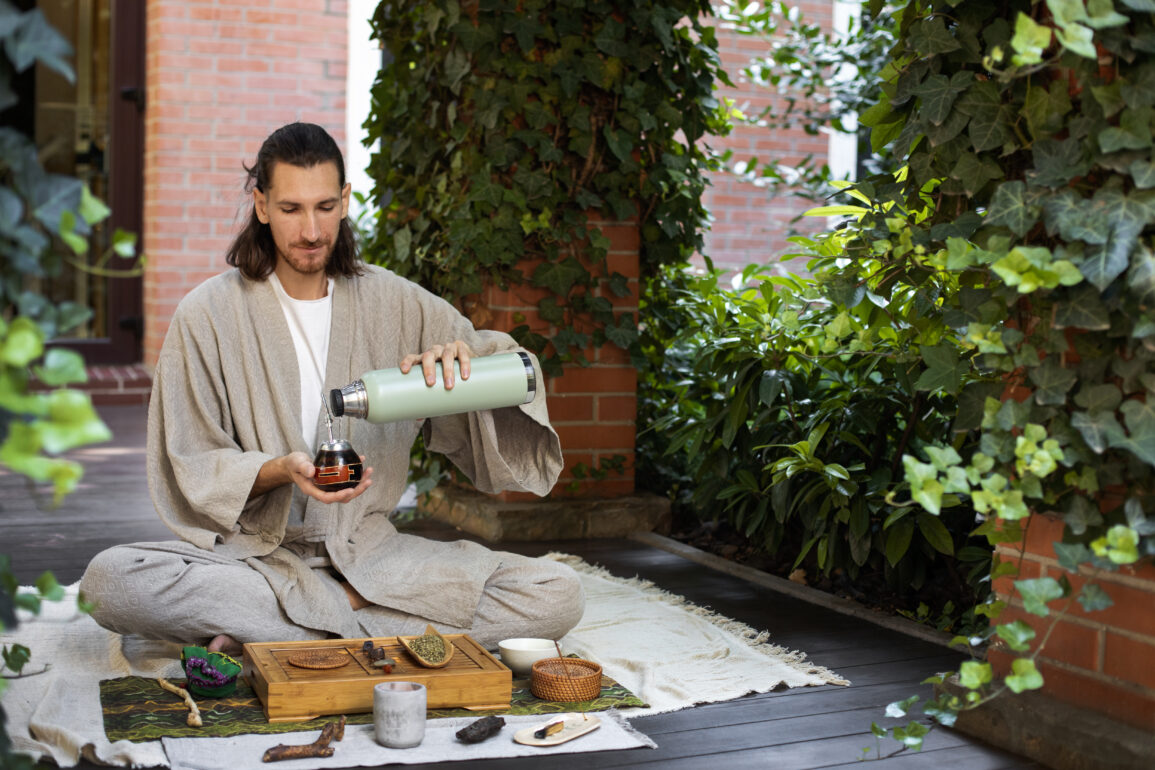 Man pouring ayurvedic tea into a cup from a bottle