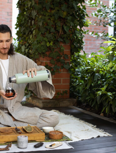 Man pouring ayurvedic tea into a cup from a bottle
