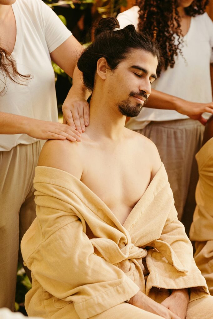 A man getting his neck massaged by a woman
