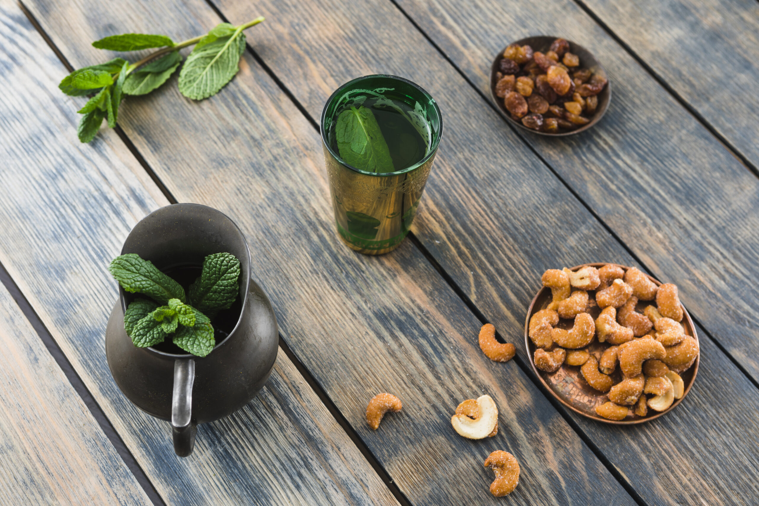 cup near pitcher with plant dried fruits nuts for ayurvedic biohacking