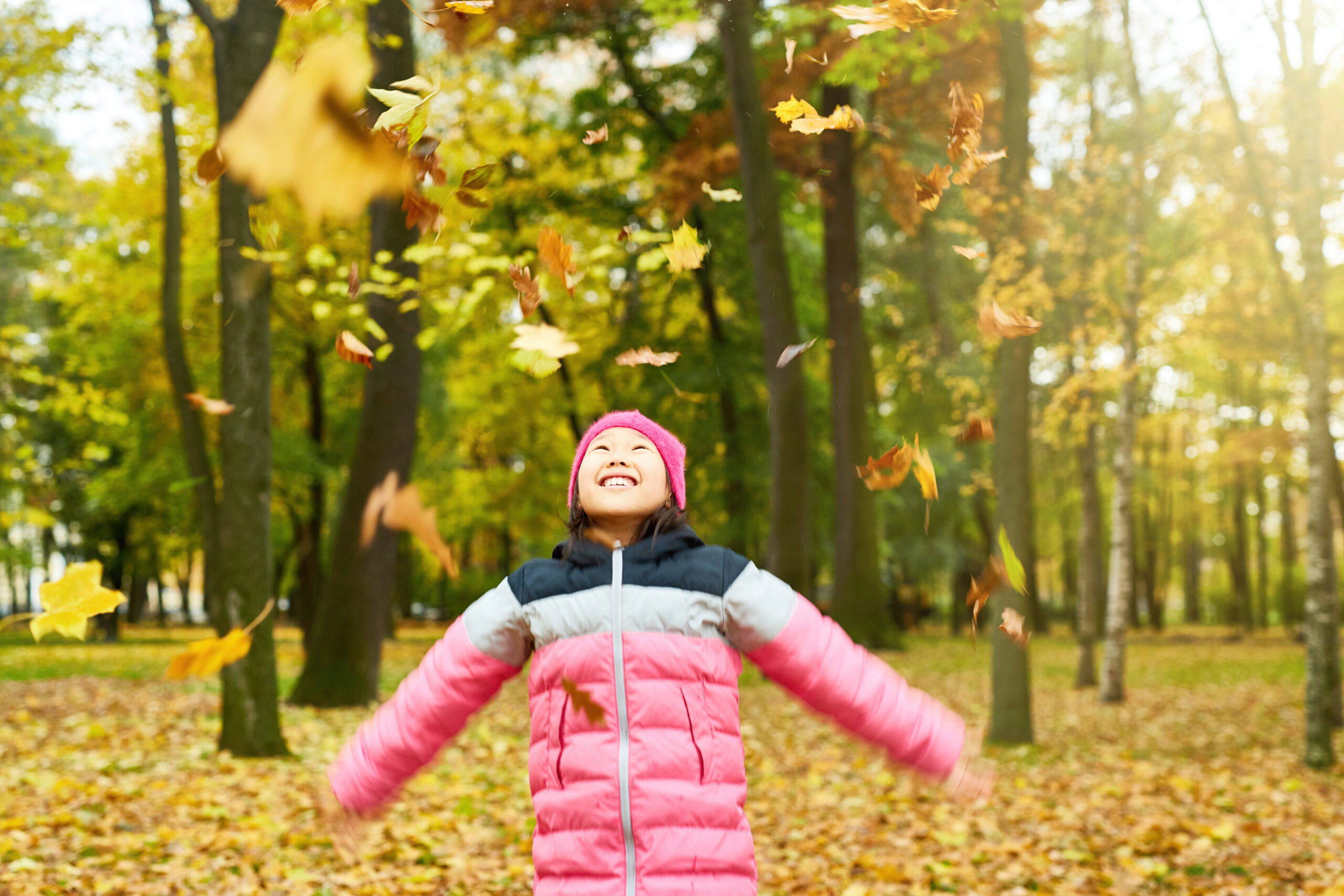 a woman inside a forest standing with arms wide apart
