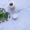 white ayurvedic medicine bottle and herbs