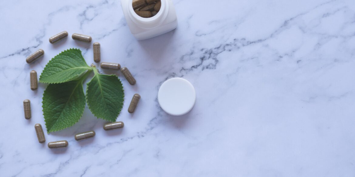 white ayurvedic medicine bottle and herbs