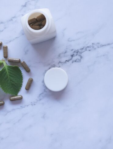 white ayurvedic medicine bottle and herbs