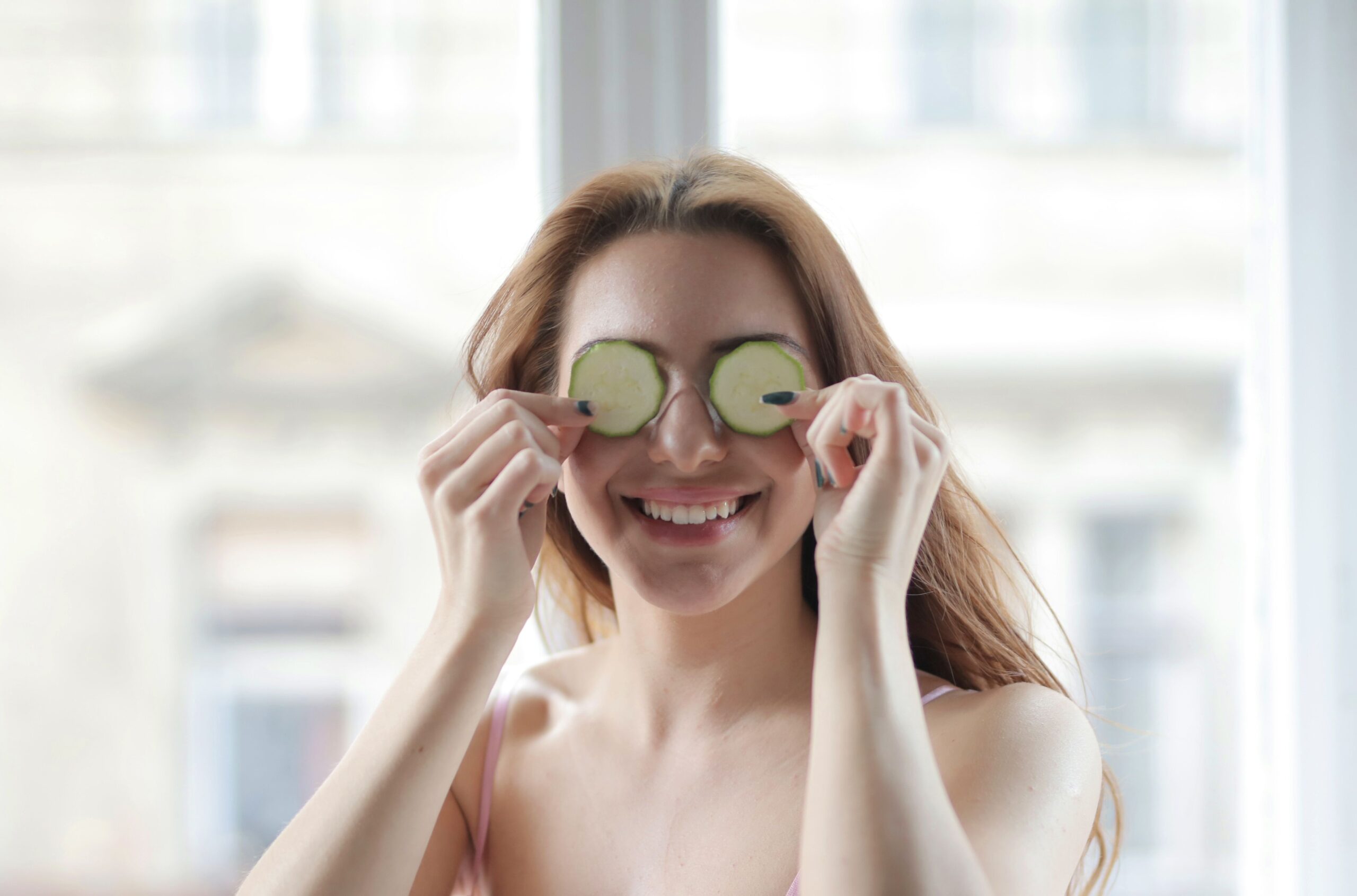 a girl with cucumber slices over her eyes for Ayurvedic Guide to Healthy Skin