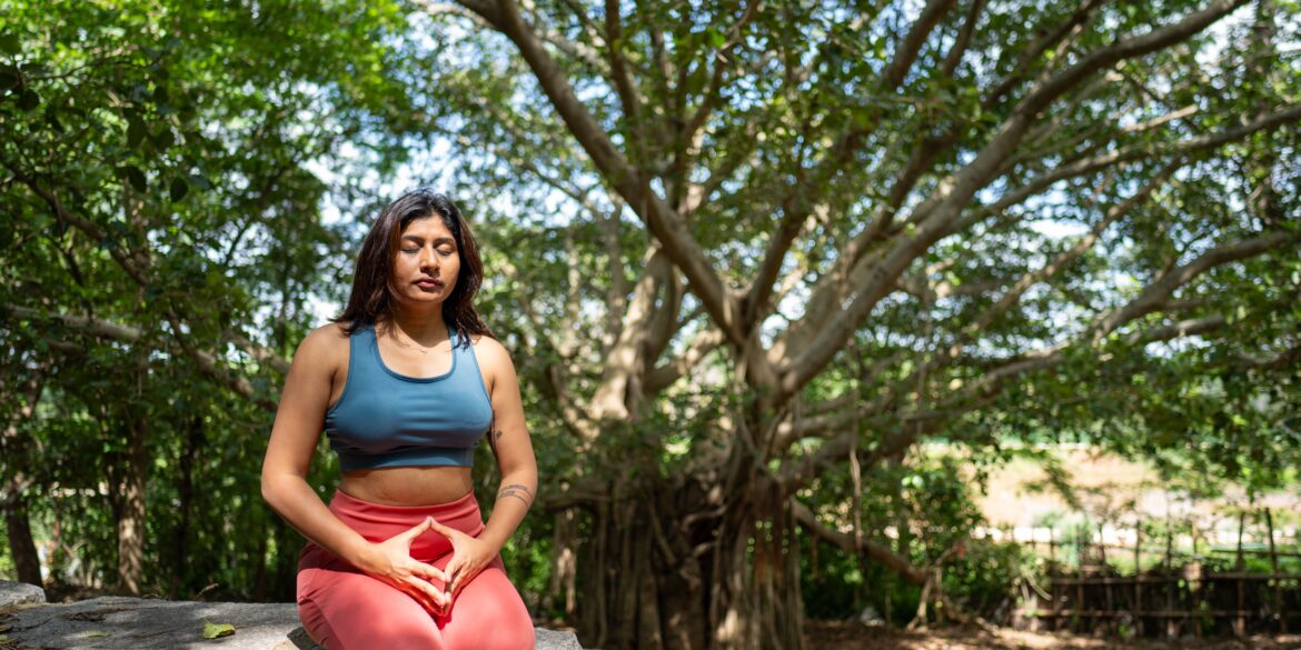 a woman doing a yoga pose in nature