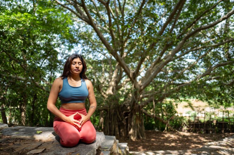a woman doing a yoga pose in nature