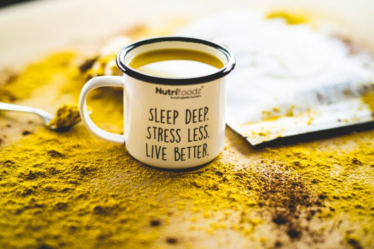 cup filled with yellow liquid that has a motivational quote written on it