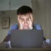 man on a desk near laptop late at night
