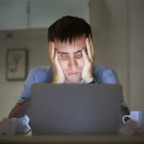 man on a desk near laptop late at night