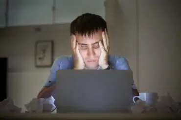 man on a desk near laptop late at night