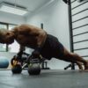 man doing push-ups with a dumble in a gym