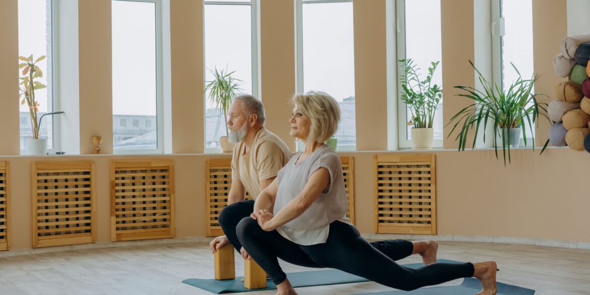 two healthy old man and woman doing a yoga pose