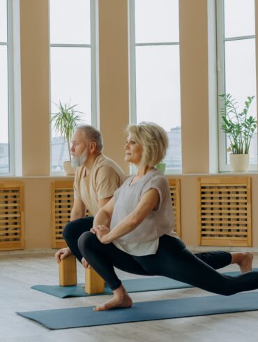 two healthy old man and woman doing a yoga pose