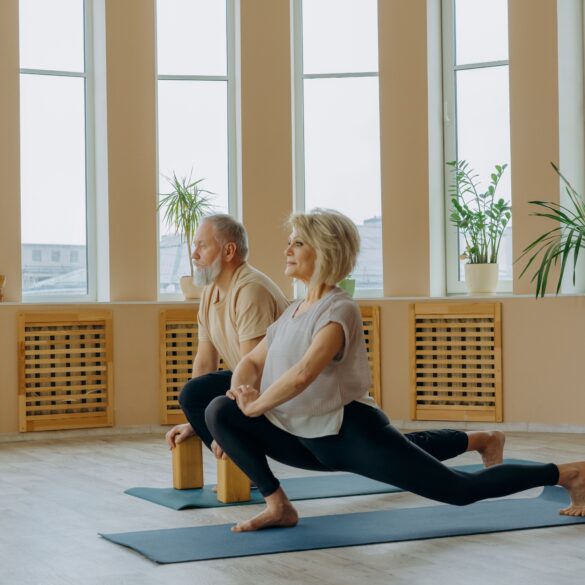 two healthy old man and woman doing a yoga pose