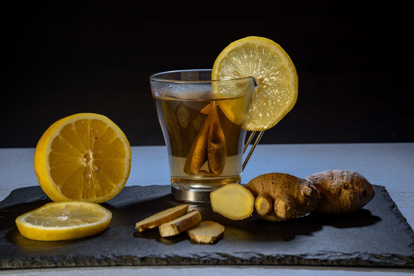 black tea with lemon on it and ginger, lime spread around it showcasing Ayurvedic immunity boosting guide
