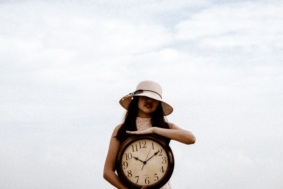 a woman holding a large clock