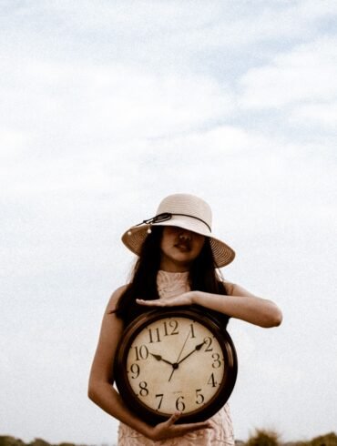 a woman holding a large clock