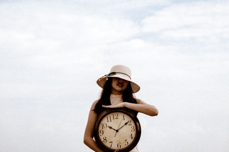 a woman holding a large clock