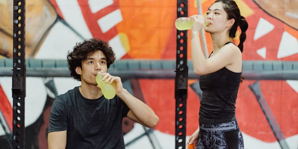 a boy and a girl drinking energy juice from bottles