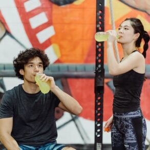 a boy and a girl drinking energy juice from bottles