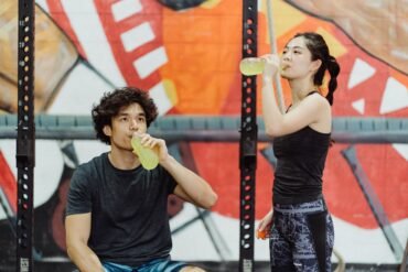 a boy and a girl drinking energy juice from bottles