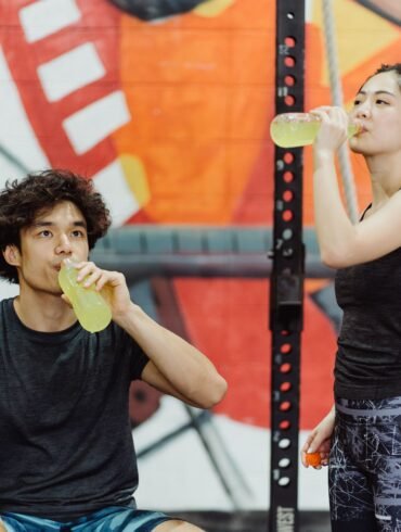 a boy and a girl drinking energy juice from bottles