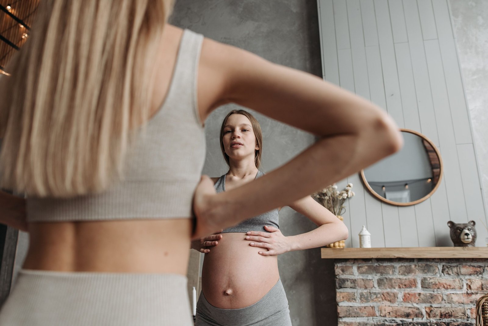 a woman looking at her pregnant belly in a mirror