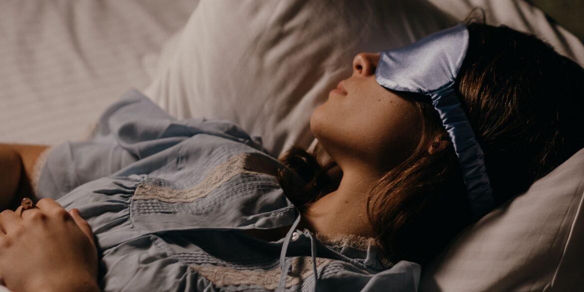 a woman sleeping peacefully with an eye mask on
