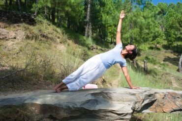 a woman doing yoga in nature for The Ayurvedic Fitness Blueprint