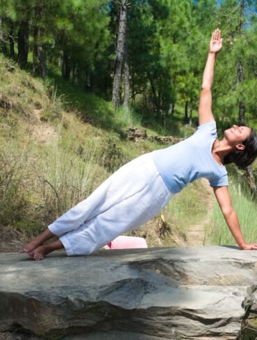 a woman doing yoga in nature for The Ayurvedic Fitness Blueprint