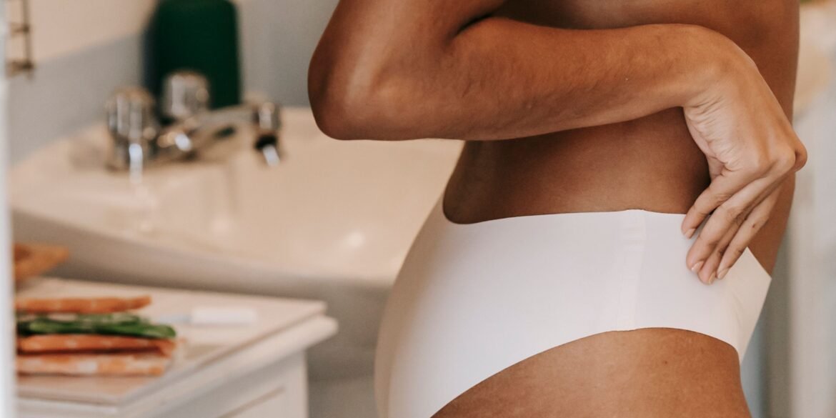 a woman in her underwear showing off her stretch marks