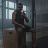 a man drinking water and taking a rest after a workout