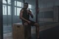 a man drinking water and taking a rest after a workout