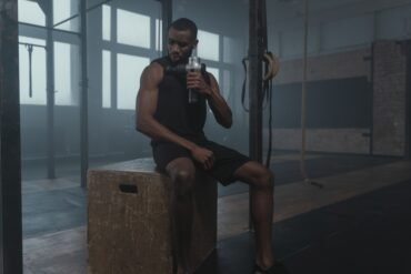 a man drinking water and taking a rest after a workout