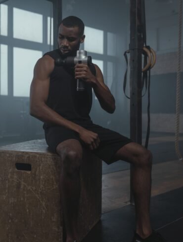 a man drinking water and taking a rest after a workout