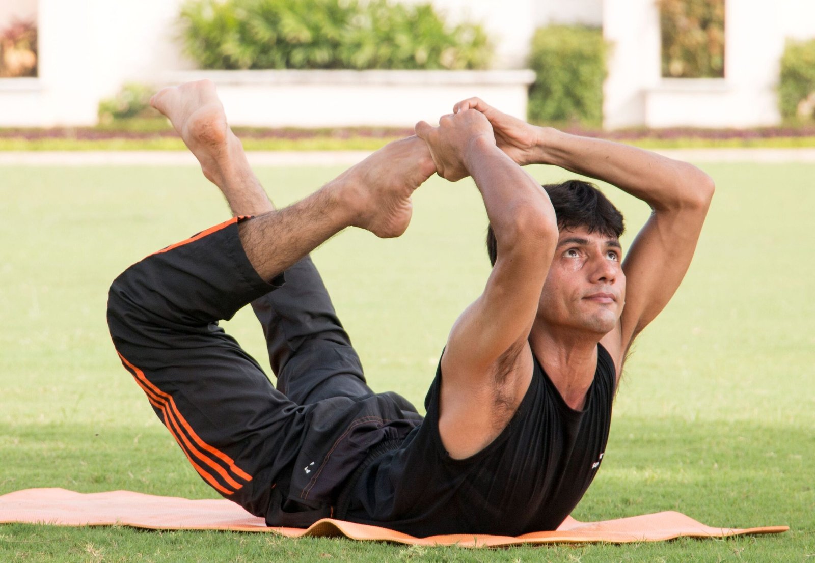 a man doing yoga in a park for The Ayurvedic Fitness Blueprint