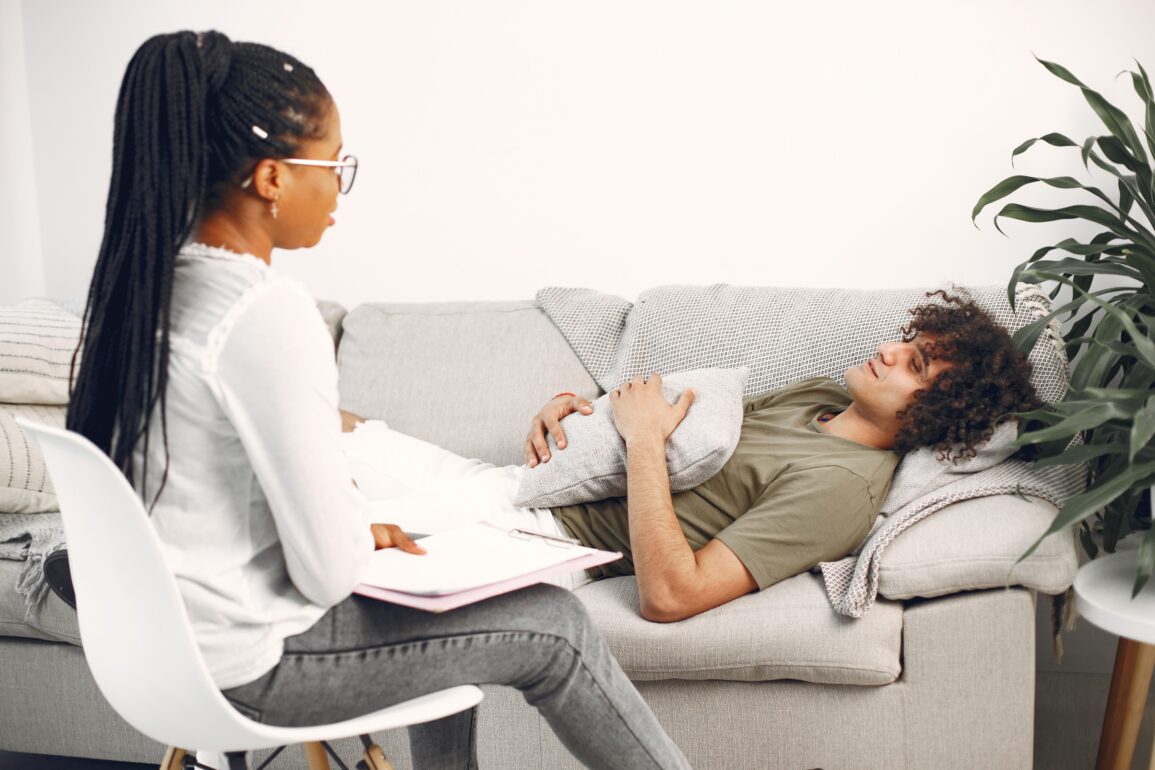a therapist sitting on a chair while her patient sits on the couch
