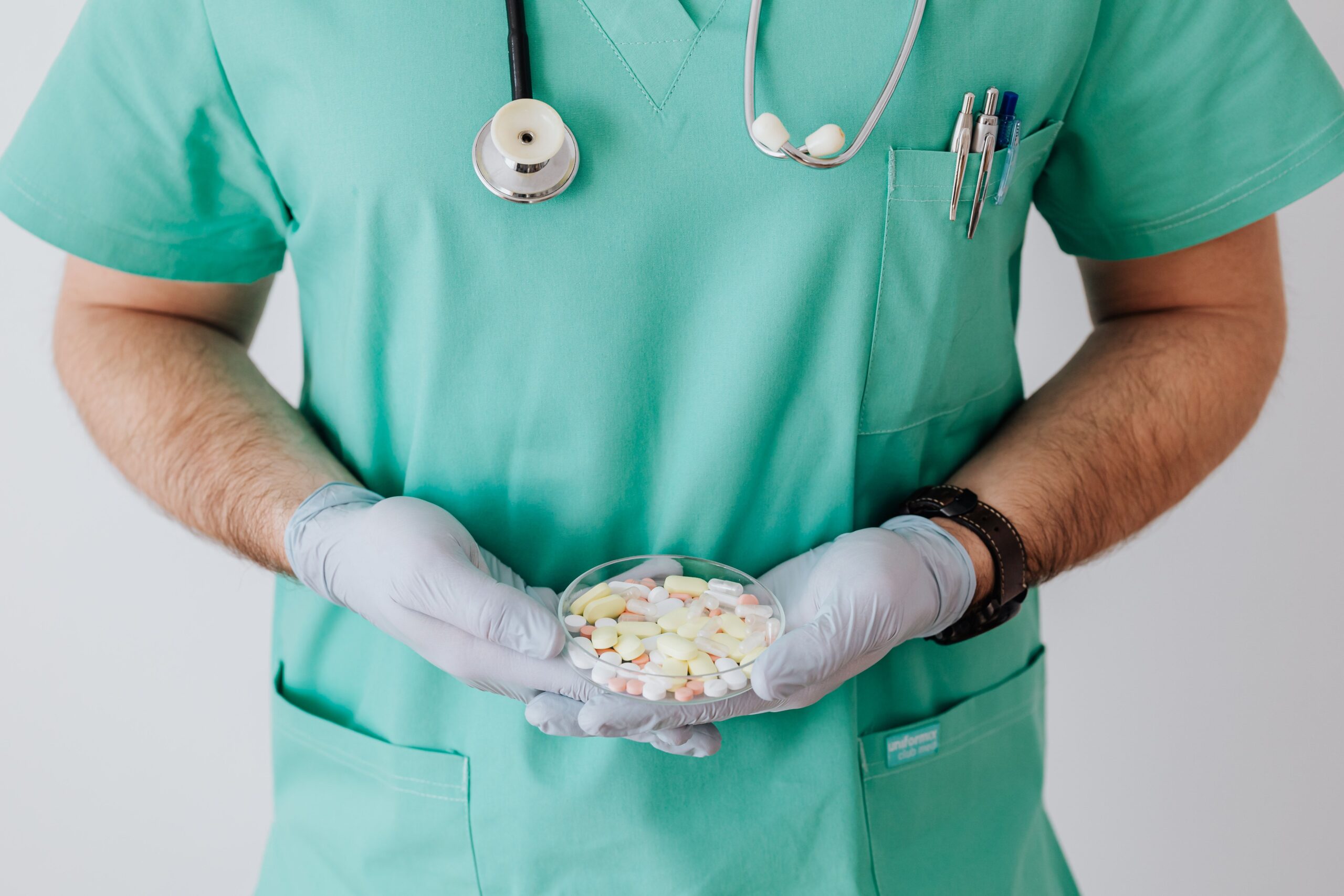 a male nurse holding a plate of medicines for health breakthroughs
