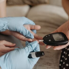 nurse measuring blood sugar of aq girl wearing gloves