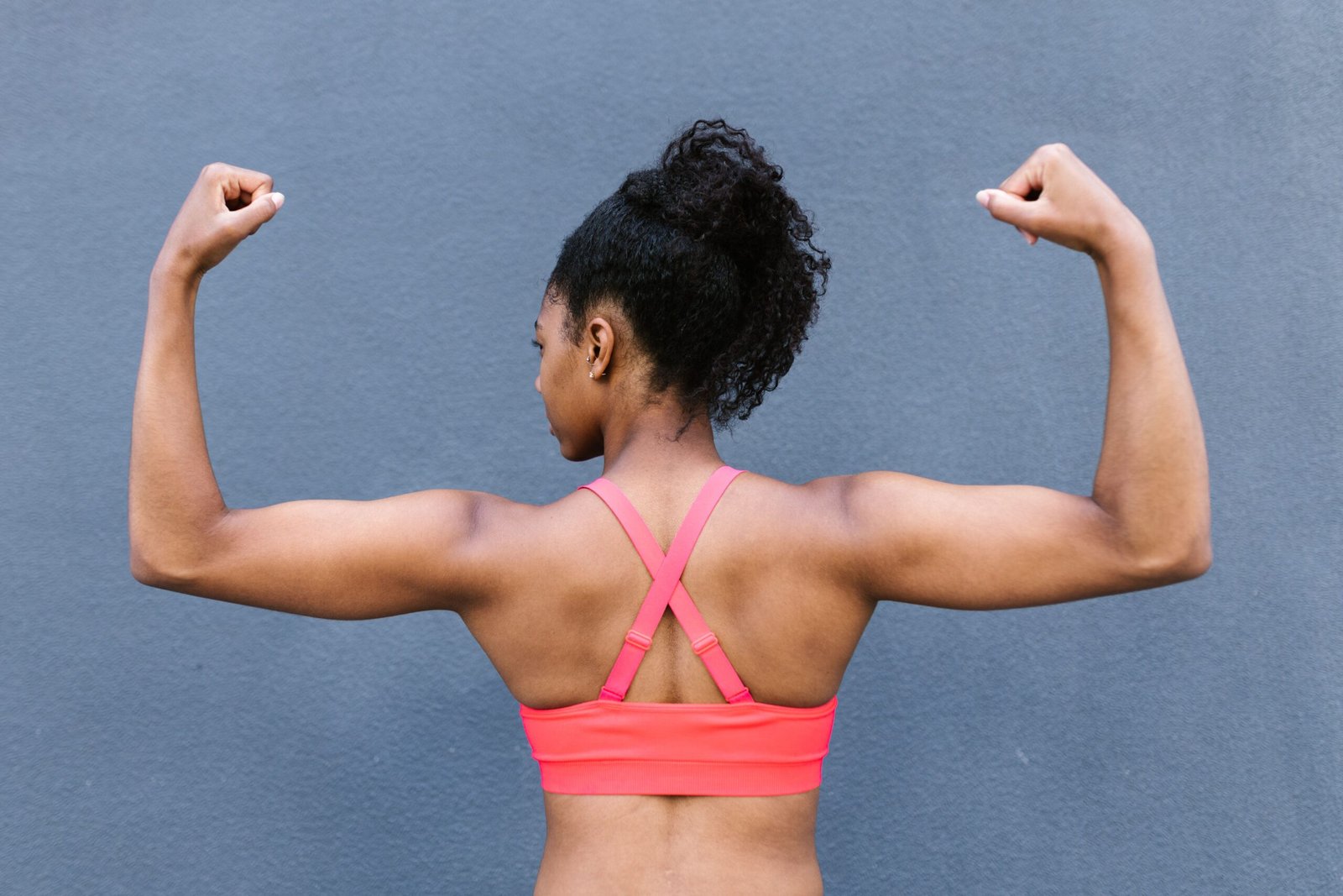 a girl flexing her biceps for stronger body