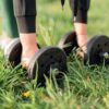 a girl picking up dumbbells in a park for Gym Exercises