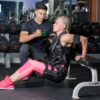 a woman training in the gym with a trainer