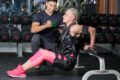 a woman training in the gym with a trainer