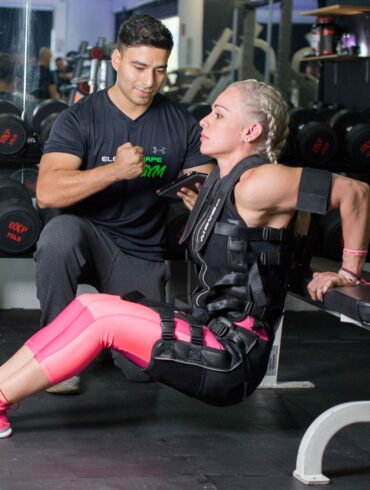 a woman training in the gym with a trainer