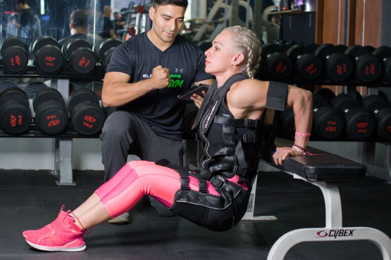 a woman training in the gym with a trainer