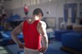 a man flexing his muscles in a bright red vest