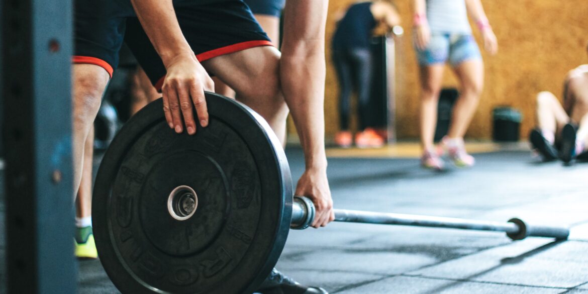 a man picking up a weight in the gym